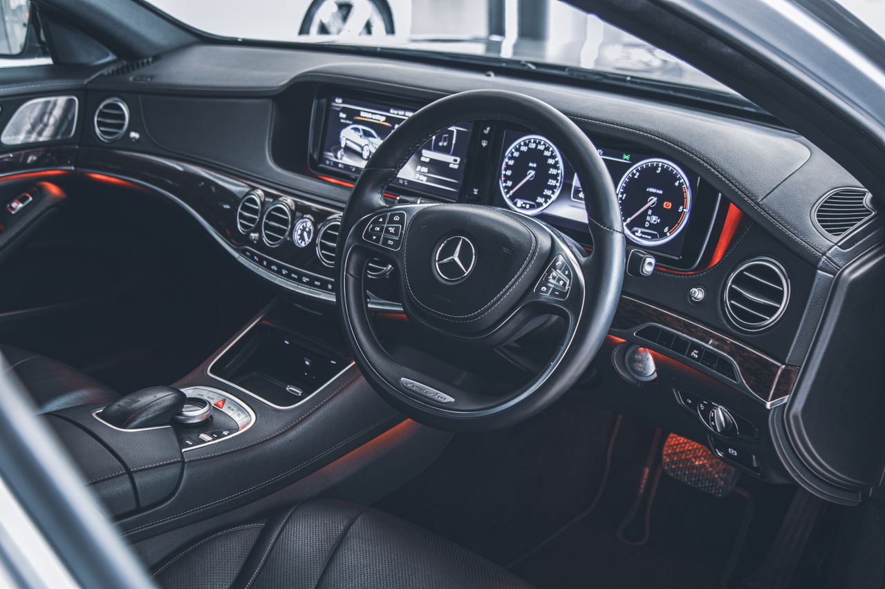 services-05 Detailed view of a luxurious Mercedes-Benz car interior showcasing the dashboard and steering wheel.