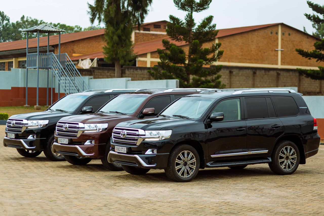why-choose-us-02 Three black Toyota Land Cruisers parked in an outdoor setting, showcasing their sleek design.